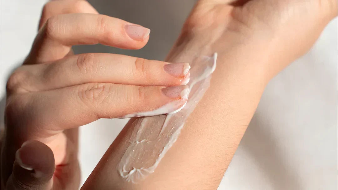 Une personne applique de la crème solaire sur son bras pour une meilleure protection de la peau.